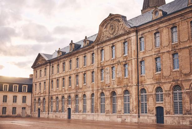 Ein großes, historisches Gebäude mit vielen Fenstern und einem verzierten Giebel.