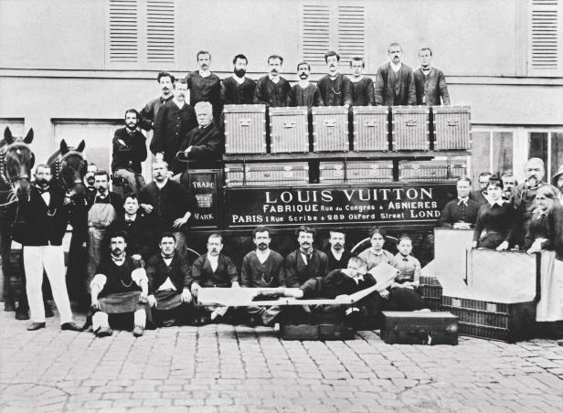 Eine historische Aufnahme der Louis Vuitton-Belegschaft vor Koffern und einem Pferdewagen.
