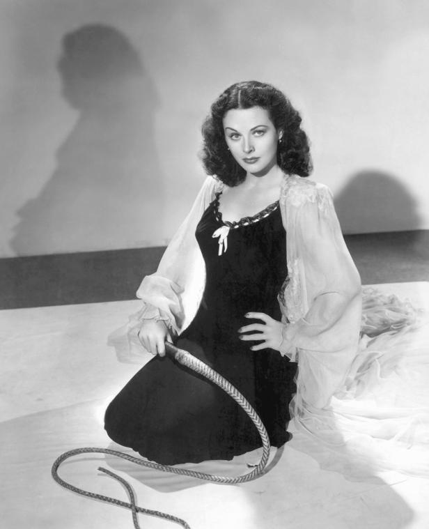 Hedy Lamarr kniet mit einer Peitsche in der Hand.