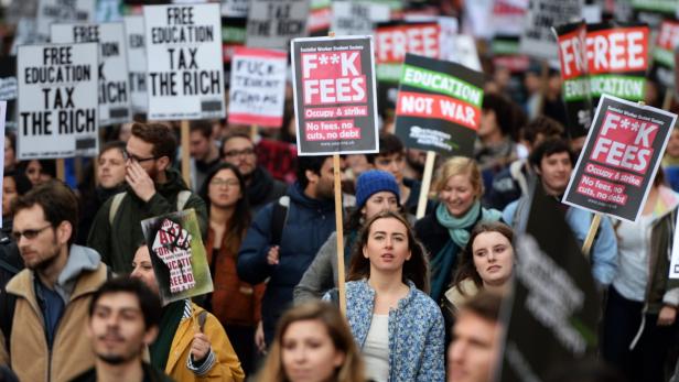 Eine Menschenmenge demonstriert mit Schildern für kostenlose Bildung und gegen Studiengebühren.