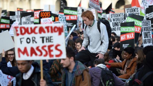 Eine Demonstration mit Schildern, die sich für Bildung und gegen Krieg aussprechen.