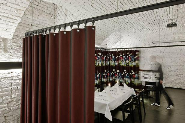 Ein Speiseraum mit Ziegelwänden und Vorhängen zur Raumteilung.