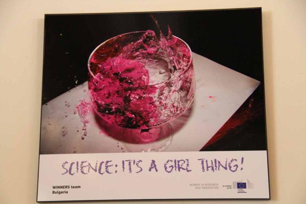 Ein Poster mit einem Glas, das mit pinkfarbener Flüssigkeit gefüllt ist, und dem Slogan „Science: It's a girl thing!“.