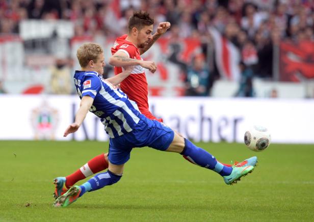 Zwei Fußballspieler kämpfen um den Ball auf dem Spielfeld.