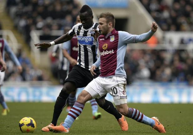 Zwei Fußballspieler kämpfen um den Ball auf dem Spielfeld.