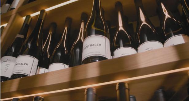 Mehrere Flaschen Wein der Marke „Martin“ und „Enthaler“ in einem Regal.