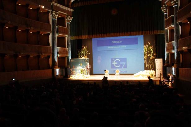 Eine Präsentation des EIROforum auf einer Bühne vor Publikum.