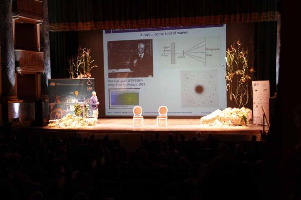 Ein Mann hält einen Vortrag über Max von Laue und Röntgenstrahlen vor einem Publikum.