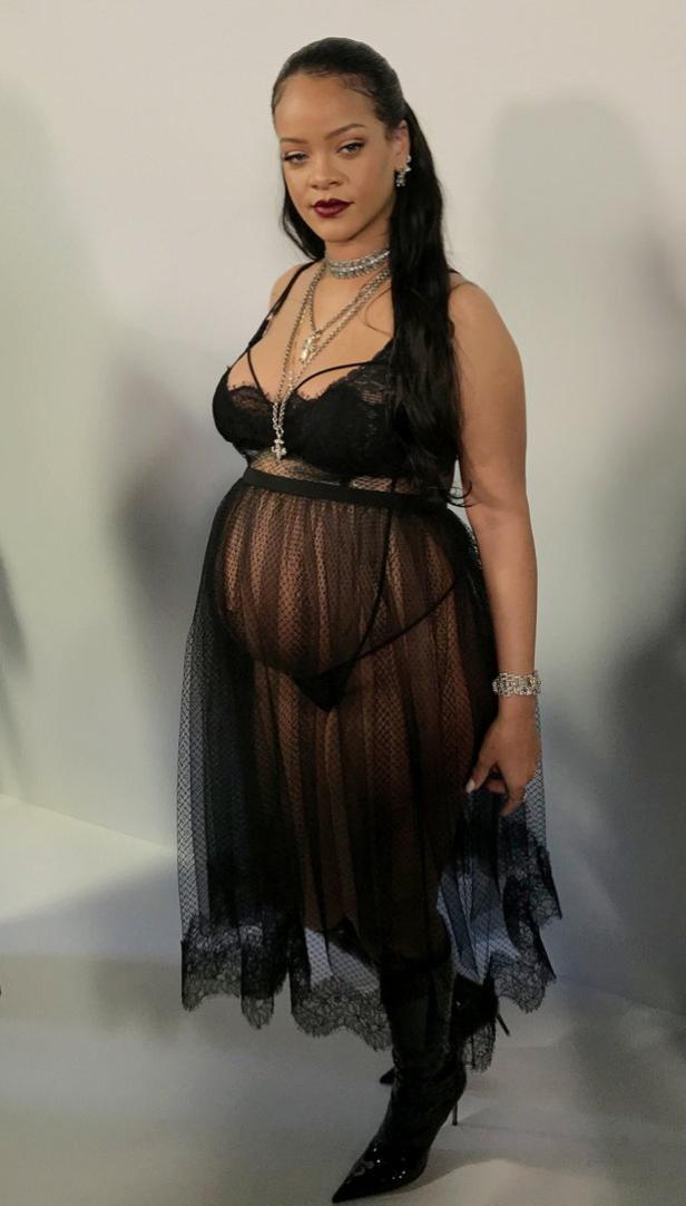 Rihanna trägt ein schwarzes Spitzenoberteil, einen transparenten Rock und Stiefel.