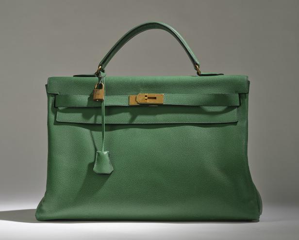 Eine grüne Hermès Kelly Bag mit goldenen Beschlägen und einem Vorhängeschloss.