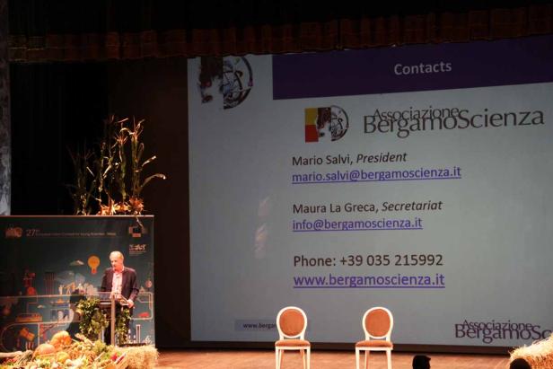 Ein Mann hält eine Präsentation auf einer Bühne von „BergamoScienza“.