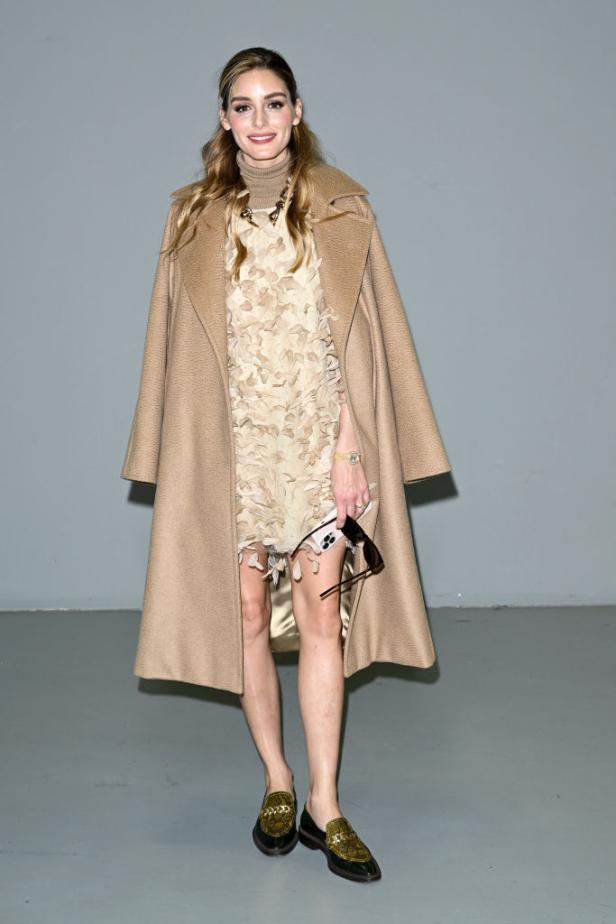 Olivia Palermo trägt einen beigen Mantel und ein Kleid mit Blattmuster.