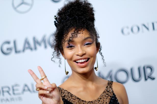 Yara Shahidi lächelt und zeigt das Victory-Zeichen auf dem roten Teppich von Glamour.