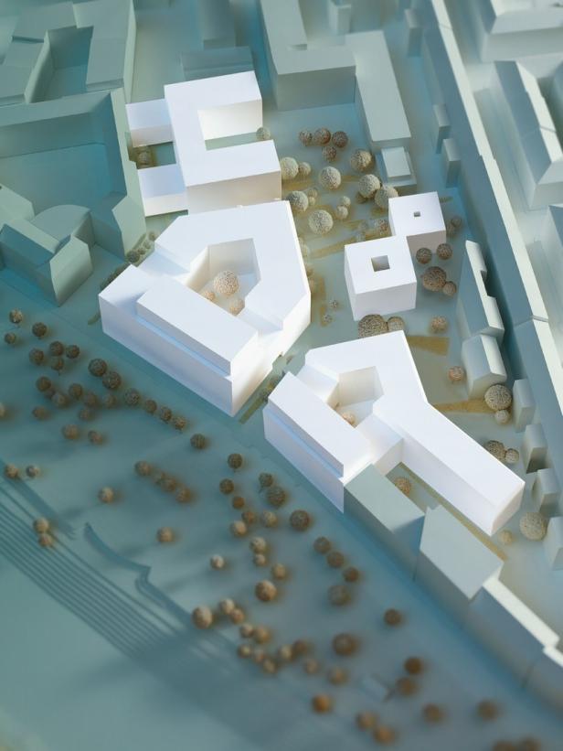 Ein Architekturmodell mit weißen Gebäuden und stilisierten Bäumen.