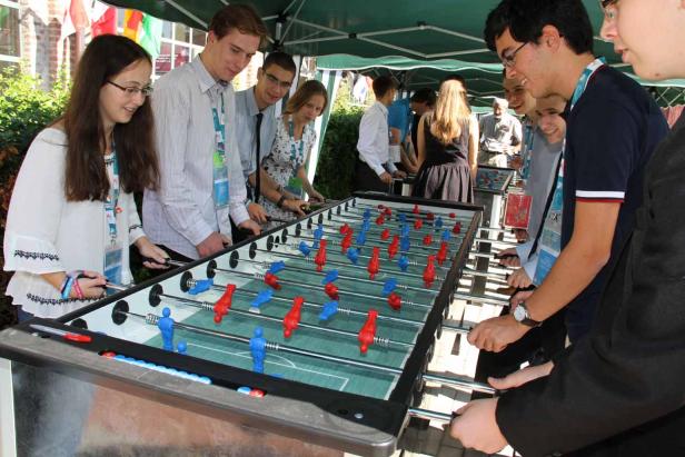 Eine Gruppe junger Leute spielt Tischfußball.