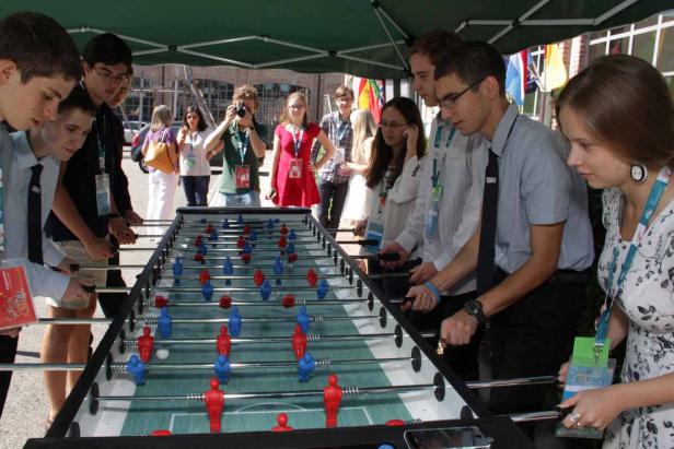 Eine Gruppe junger Leute spielt Tischfußball.