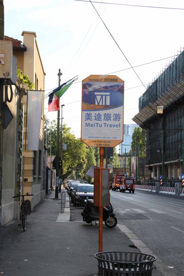 Ein Straßenschild wirbt für „MeiTu Travel“ in Mailand.