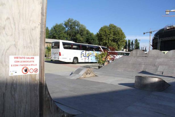 Ein Bus der Marke Frigerio steht neben einem Skatepark.