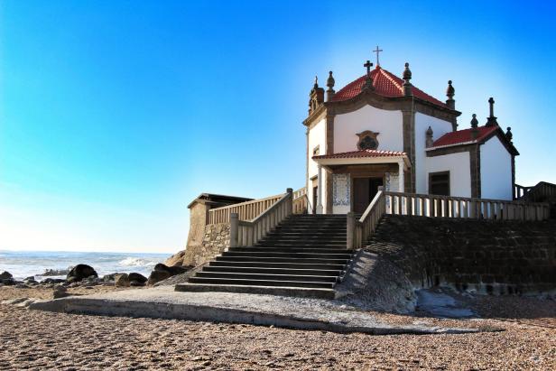 Die Capela do Senhor da Pedra steht auf einem Felsen am Strand.