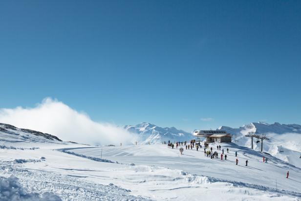 Auf einem schneebedeckten Berg befinden sich Skifahrer in der Nähe eines Skilifts.