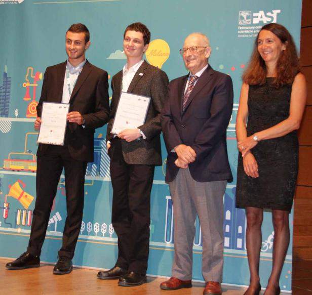 Zwei junge Männer erhalten auf einer Bühne eine Auszeichnung.