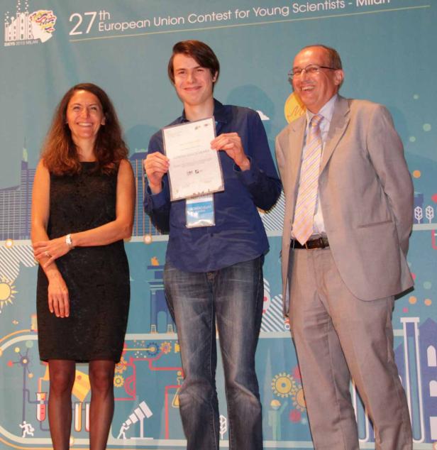 Ein junger Mann hält eine Urkunde bei der Preisverleihung des Europäischen Wettbewerbs für junge Wissenschaftler.