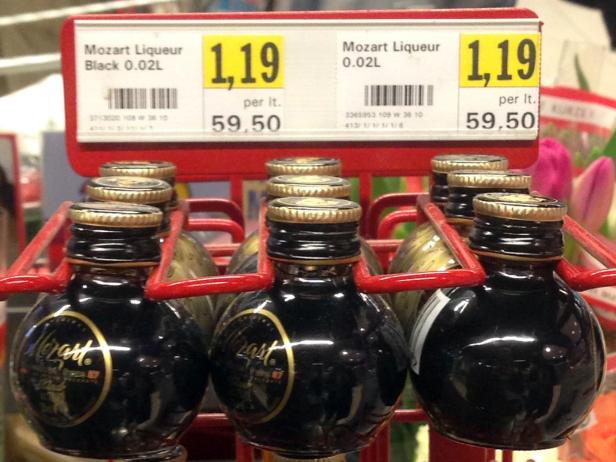 Mehrere Flaschen Mozart Black Schokoladenlikör in einem Verkaufsregal.