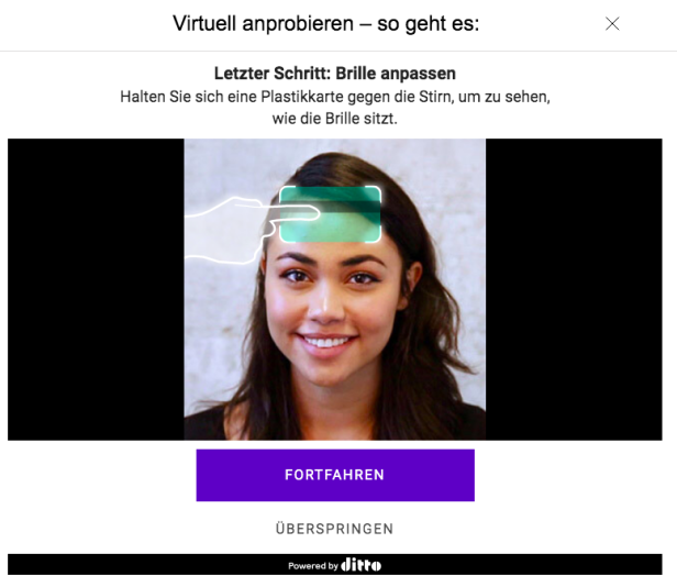 Eine Frau hält eine Plastikkarte an ihre Stirn, um eine virtuelle Brille anzupassen.