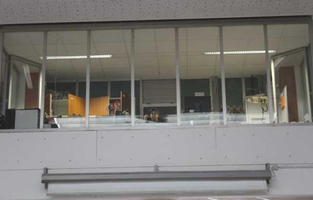 Ein Mann telefoniert in einem Büro, das durch eine Glaswand sichtbar ist.