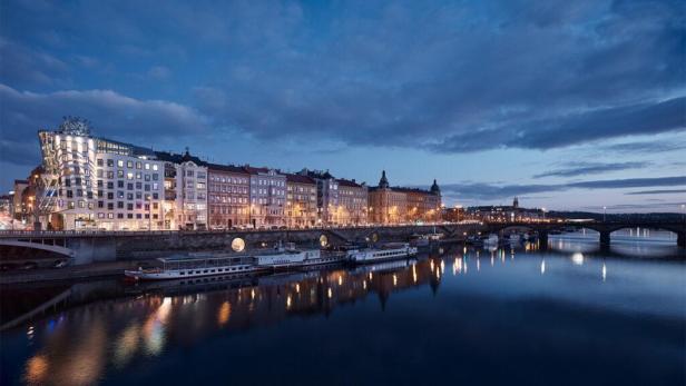 Das tschechische Nationaltheater und das Tanzende Haus in Prag bei Nacht am Ufer der Moldau.