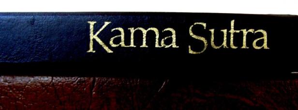 Nahaufnahme eines Buches mit dem Titel „Kama Sutra“ in goldener Schrift.