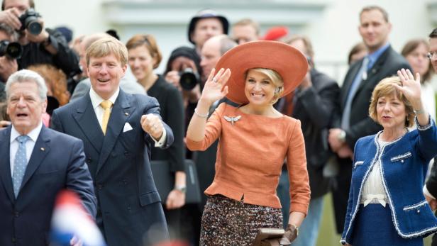König Willem-Alexander, Königin Máxima und weitere Würdenträger winken in die Menge.
