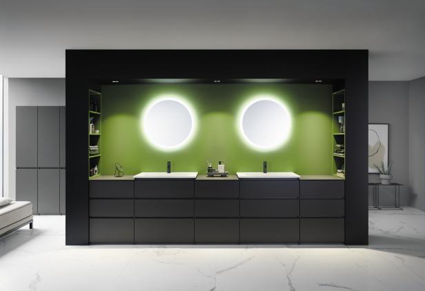 Ein modernes Badezimmer mit zwei Waschbecken und runden Spiegeln mit Hintergrundbeleuchtung.
