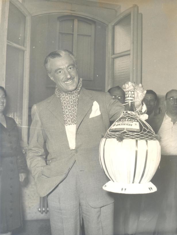 Ein Mann im Anzug posiert mit einer großen Flasche Chianti Classico von Ruffino.