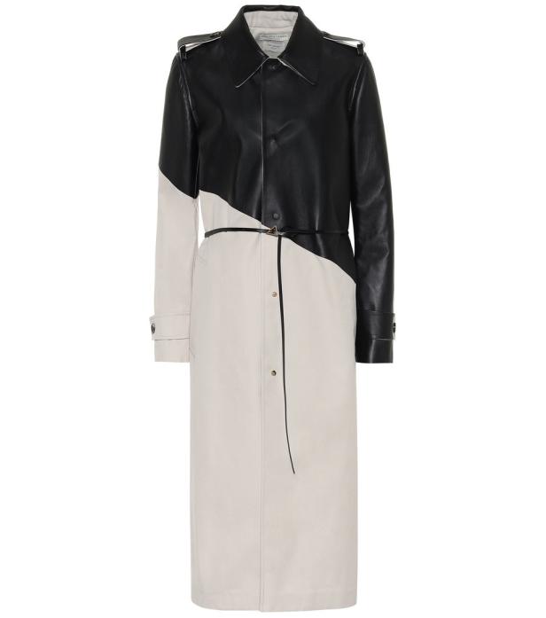 Ein zweifarbiger Trenchcoat in Schwarz und Beige mit einem schmalen Gürtel in der Taille.