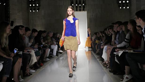 Eine Frau läuft auf einem Laufsteg während einer Modenschau.