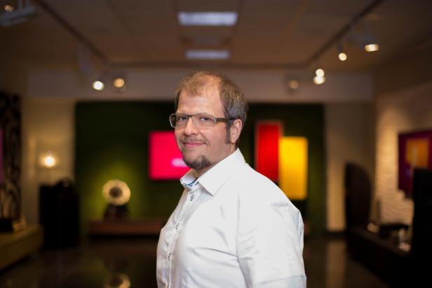 Ein Mann mit Brille und Bart schaut in die Kamera.