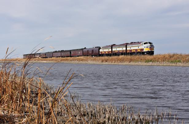 Ein Zug der Canadian Pacific fährt an einem Gewässer entlang.