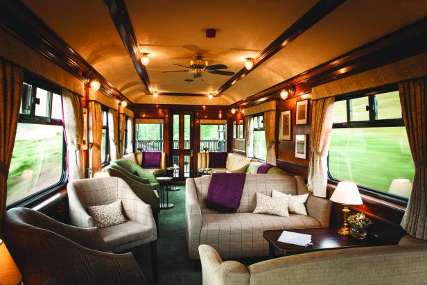 Der luxuriöse Salonwagen eines Zuges mit Sesseln und Sofas ist einladend gestaltet.