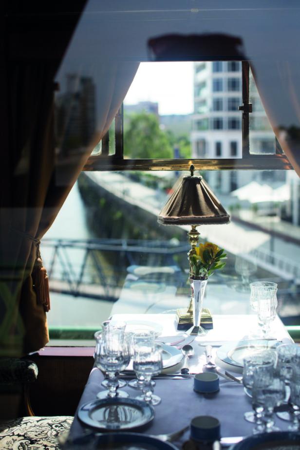 Ein gedeckter Tisch mit Blick auf einen Kanal und Gebäude.
