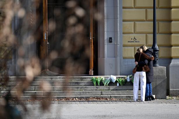 People mourn outside Malmo Latin School the day after two women died, in Malmo