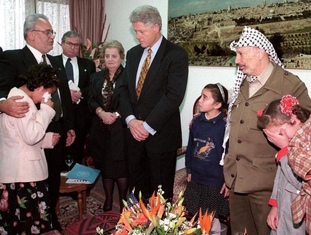 FILE PHOTO: Palestinian chief negotiator Saeb Erekat (L) comforts a Palestinian girl whose father is being held in an Israeli jail as she tells her story to Secretary of State Albright, Bill Clinton, and Arafat