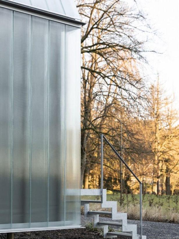 Eine Außentreppe führt zu einem modernen Gebäude mit Glasfassade.