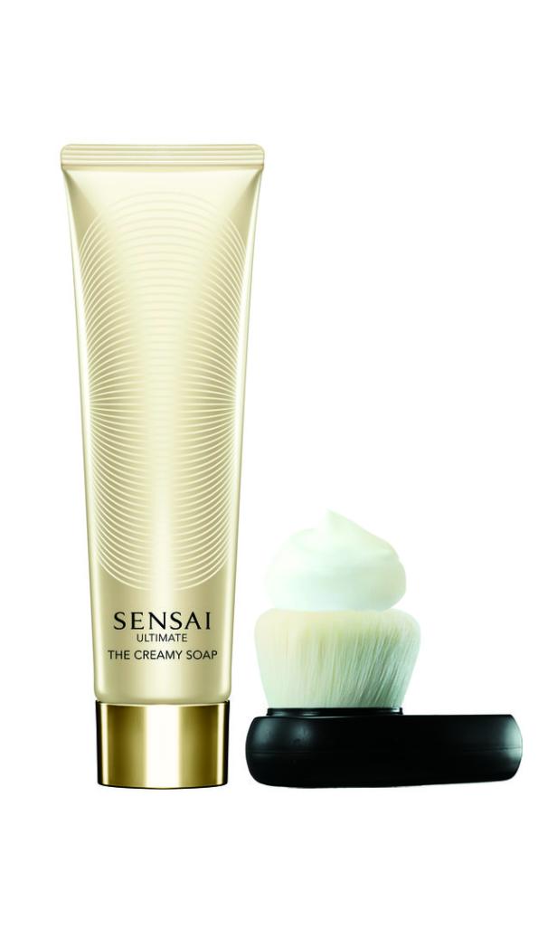 Eine Tube „Sensai Ultimate The Creamy Soap“ mit einem Pinsel und Seifenschaum.