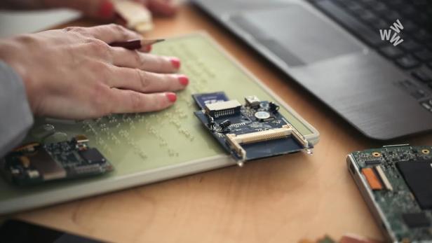 Eine Person erstellt eine Braille-Zeichen-Übersetzung für elektronische Bauteile.