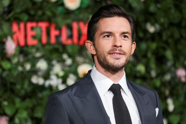 Jonathan Bailey vor einer Wand mit dem Netflix-Logo.