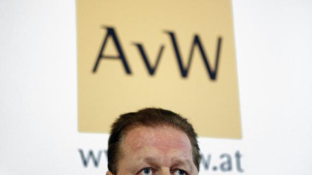 Ein Mann steht vor einem Schild mit der Aufschrift „AvW“.