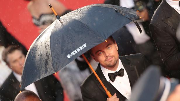 Leonardo DiCaprio unter einem Regenschirm mit der Aufschrift „Gatsby“.