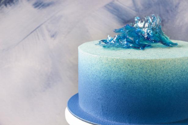 Ein blauer Ombre-Kuchen ist mit blauem Zuckerguss verziert.
