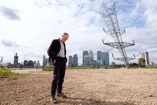 Alex Chinneck steht vor seiner Skulptur „A Bullet from a Shooting Star“ in Greenwich.